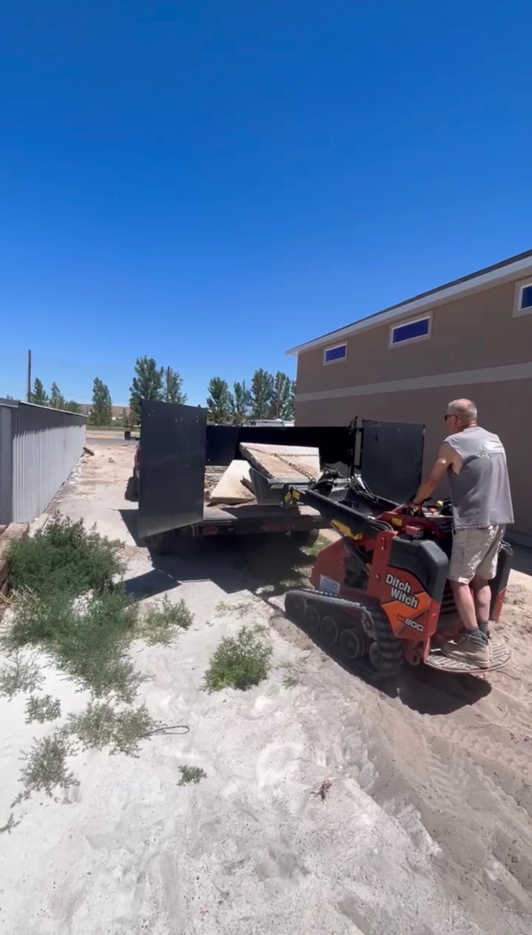 Ditch Witch unloading from trailer at gravel delivery job